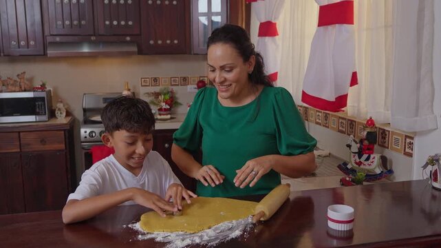 Mother and son baking Christmas cookies together in the kitchen
