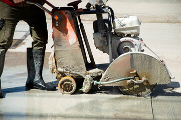 Workers are using a concrete road cutter.