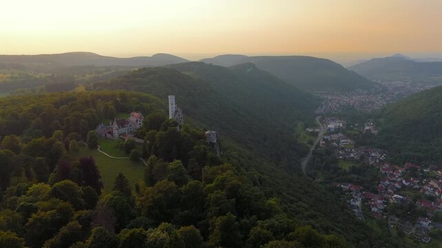 Cinematic drone travel video Lichtenstein Castle, Baden-Wuerttemberg, Germany. A mountain fortress glowing in summer sunset light. Schloss Lichtenstein Wuerttemberg, Deutschland, Luftbild. 