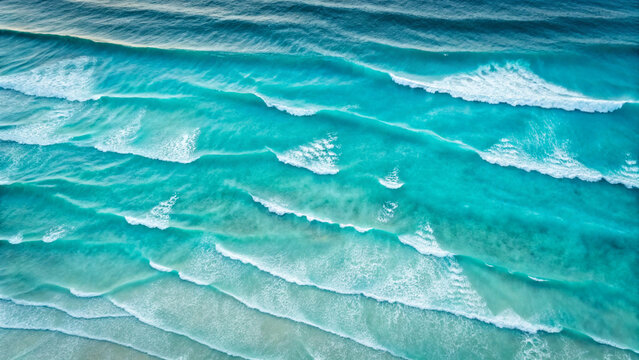 Aerial View of Turquoise Ocean Waves Breaking on a Sandy Shoreline water