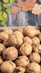 A close-up view of numerous walnuts piled high in a wooden container, showcasing their textured, rich brown shells and natural beauty.