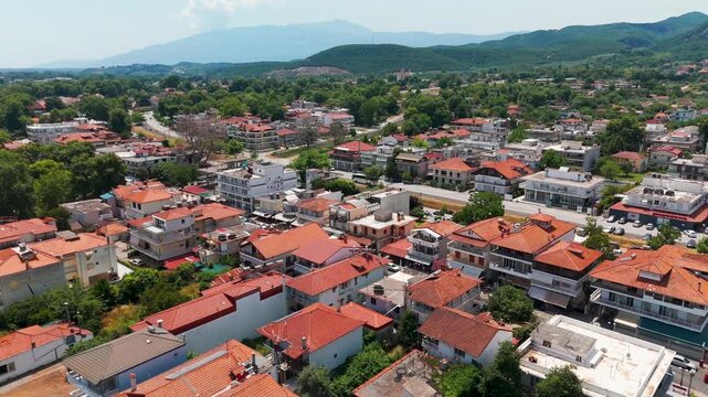 Aerial Drone Panning Down Over Rooftops In The Coastal Town Of Platamon, Pieria, Greece On A Sunny Summer Afternoon.