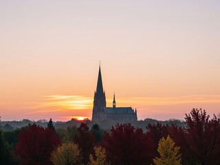 Fototapeta premium Silhouette of gothic cathedral with tall spires at colorful sunset sky autumn season, peaceful religion faith spirituality inspirational architecture landscape background concept