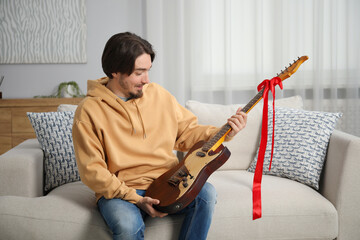Dreams come true. Happy man with guitar at home