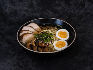 A vibrant and inviting ramen bowl featuring succulent chashu pork, perfectly softboiled eggs, and...