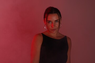 Beautiful woman in neon lights against red background