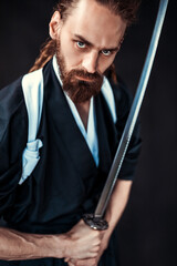 Intense bearded warrior holding sword in traditional attire