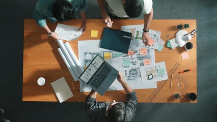 Time lapse of civil engineer team preparing for working at meeting room. Top down aerial view of smart architect walking at table and place project plan while design building construction. Symposium. © InfiniteFlow