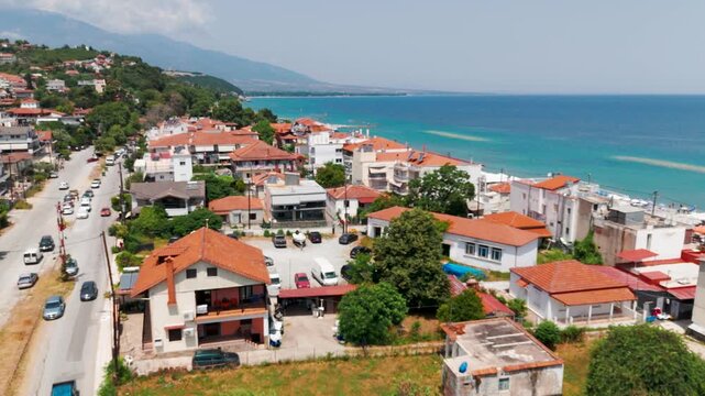 Aerial Drone Shot Of Platamon Town Rooftops Moving Towards The Aegean Sea In Pieria Region, Greece On A Sunny Summer Afternoon.