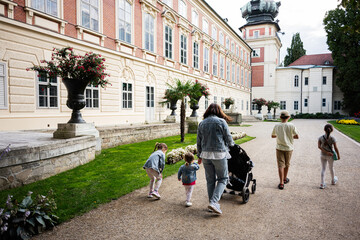 Obraz premium Family strolling at the park near a historic building in Lancut, Poland