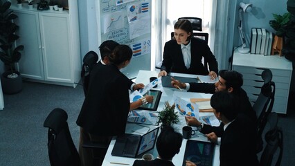 Top view of investor handed financial document to manager while explain marketing idea at meeting table. Diverse people looking at growing graph while listen business team discussion. Directorate.