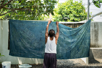 A craftsman dyes fabric using traditional methods in Pekalongan, Indonesia, August 2025. The manual...