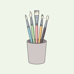 Fototapeta premium Five art brushes in a light colored holder against a pale background.