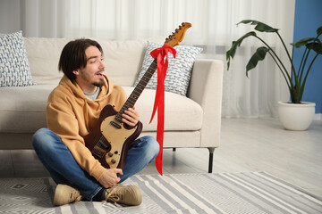 Dreams come true. Excited man with guitar at home, space for text