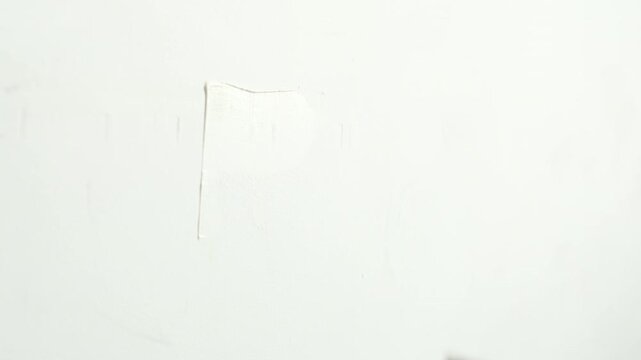 Worker Applying Wall Putty With A Spatula While Smoothing The Wall