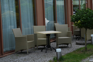 Open-plan restaurant dining area with several tables and wicker chairs.