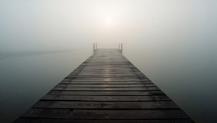 Obraz premium Foggy pier stretching out into the unknown, disappearing into a white mist. Tranquil, ethereal scenery