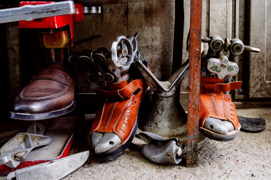 Old leather skate boots and shoe machinery in workshop - Powered by Adobe
