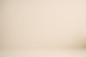 Empty beige studio background with a subtle shadow on the right side, perfect for product placement and design