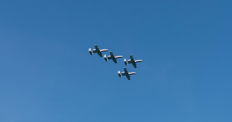 Military air force fighter jet airplane in full flight against blue sky. Four fighter jet in V shape in sky. Squadron. Air Force Day. Aircraft squadron on a mission. US air force