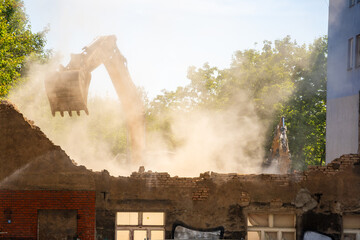 Excavator demolishing an old building on a city street. Concept of urban redevelopment, structural...