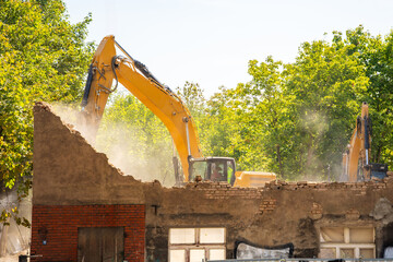 Excavator demolishing an old building on a city street. Concept of urban redevelopment, structural...