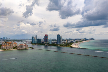 Fototapeta premium Luxury yacht cruising near Miami skyline. Aerial view of boats on turquoise waters in Miami. Yacht retreat in South Florida Miami. Miami cityscape with sailing vessels. Waterfront panorama.