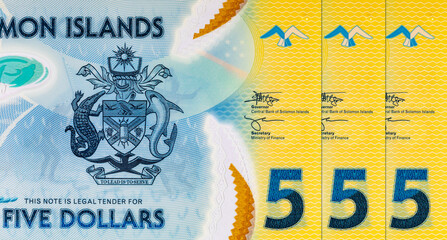 5 Dollars Solomon Islands. Polymer banknote fragment shows Tuna fish, coat of arms, issued 2019 ....