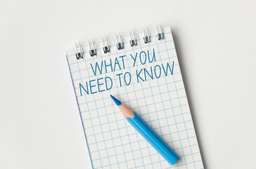 A blue pencil is on a notebook with the words What you Need to Know written in