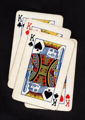 Vintage playing cards showing four of the same value isolated on a black background.