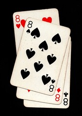 Vintage playing cards showing four of the same value isolated on a black background.