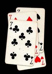 Vintage playing cards showing four of the same value isolated on a black background.