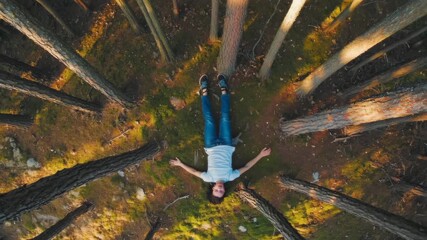 Young man relaxing lying on the ground in a pine forest - Powered by Adobe