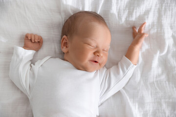 Cute newborn baby sleeping on bed, top view