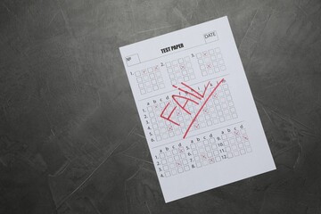 Student passing exam. Answer sheet with word Fail on gray textured table, top view. Space for text