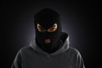 Criminal man in mask on dark background