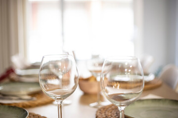 Empty wineglasses on an empty table full of cutlery and tableware before a party