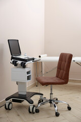 Modern ultrasound machine, chair and examination bed in clinic