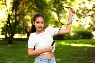Portrait of smiling little girl with badminton racket in park