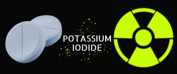 Potassium iodide pills and warning sign on black background. Iodine consumption during radioactive...