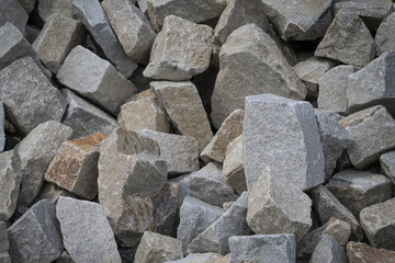 Broken stones stacked, about the size of a human head, outdoors.

