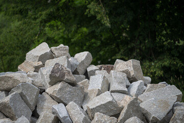 Broken stones stacked, about the size of a human head, outdoors.
