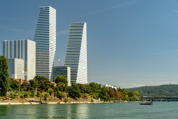 Two Roche Pharma skyscrapers in Basel on the banks of the Rhine on a sunny day. 