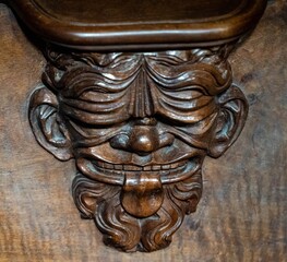 Old man with a beard sticking out his tongue - a funny and surprising wooden ornament from the wooden nobles' seat from the cathedral in Basel	
