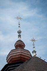 Beautifully decorated spires on a church with wooden shingles.
