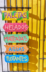 Boards with colorful advertisements for the drinks sold in a Cholula store.