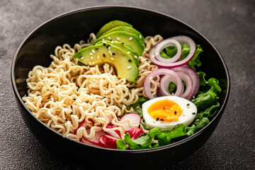 Vegetarian noodle bowl avocado, noodles, egg, vegetables tasty snack fresh delicious gourmet food background on the table rustic food top view copy space keto and paleo diet vegetarian food