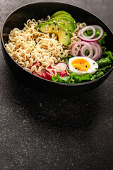 Vegetarian noodle bowl avocado, noodles, egg, vegetables tasty snack fresh delicious gourmet food background on the table rustic food top view copy space keto and paleo diet vegetarian food
