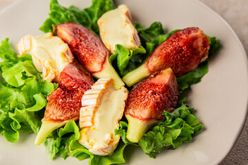 Salad figs, soft cheese, green leaf lettuce tasty snack fresh delicious gourmet food background on the table rustic food top view copy space keto and paleo diet vegetarian food