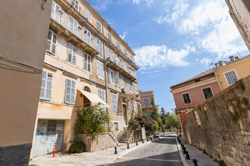Charming residential square surrounded by traditional Greek buildings with wrought iron balconies,...
